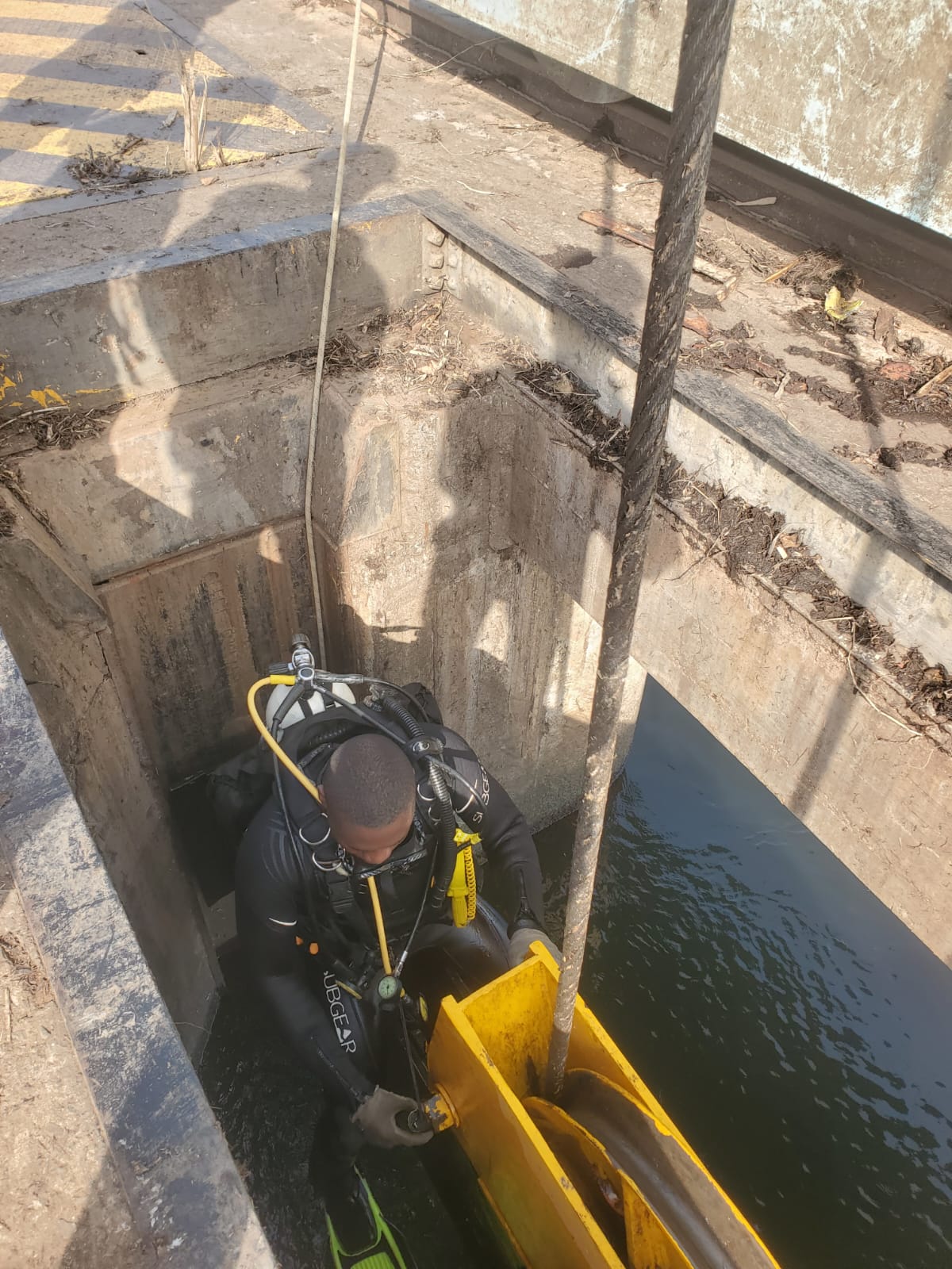 Diver descending into a dam culvert structure
